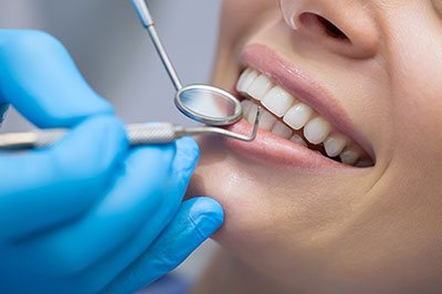 A dental professional performing oral care on a patient s teeth.