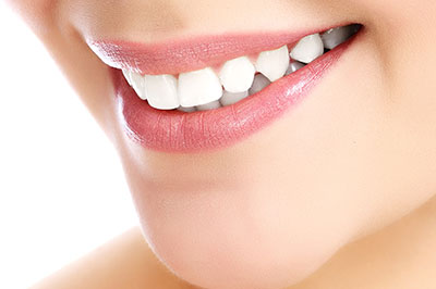 A close-up image of a person s smiling face, showcasing their teeth and lips, with an emphasis on dental hygiene.