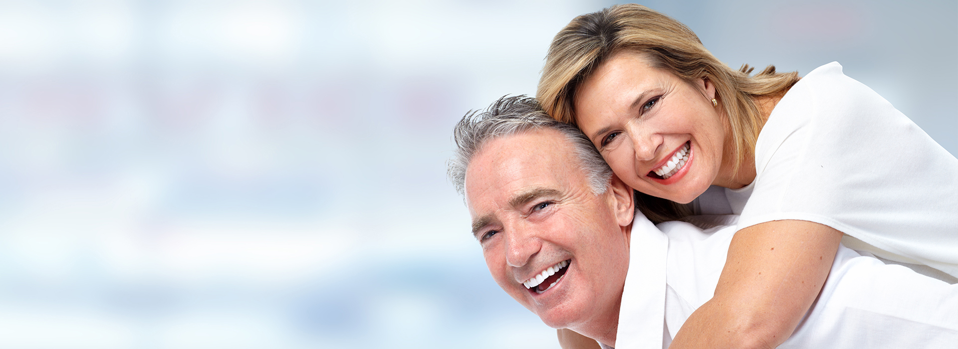 The image shows a man and woman embracing each other with smiles on their faces.