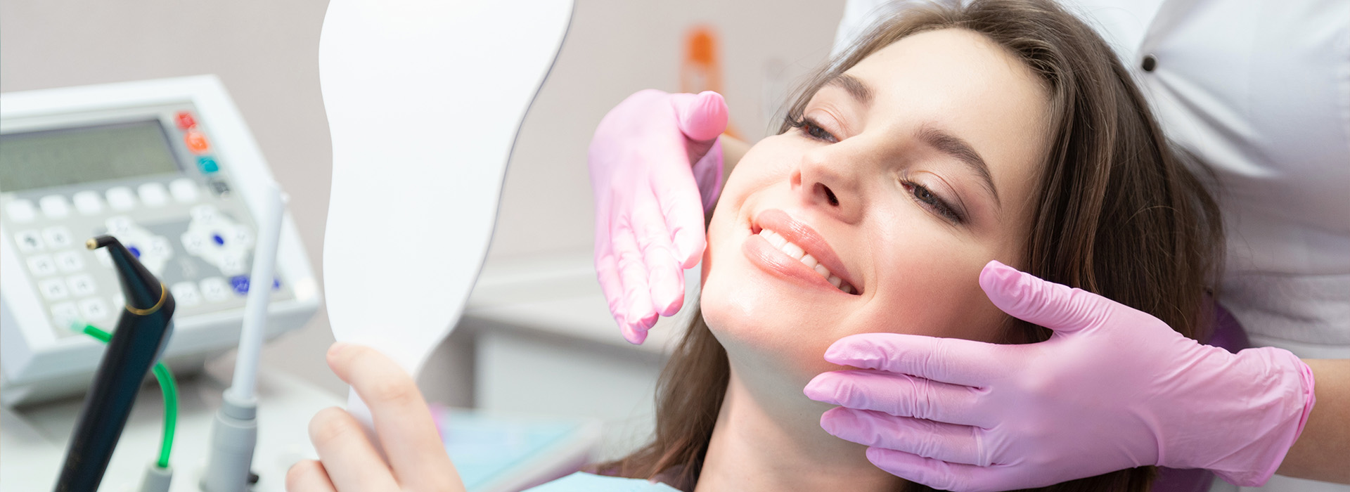 A woman receiving dental care with a dental hygienist performing the procedure.