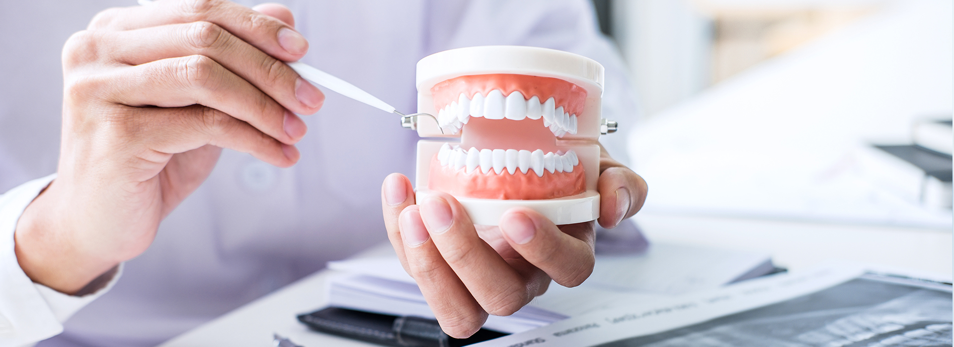 A person s hand holding a toothbrush with toothpaste over a document, suggesting dental hygiene practices related to health care or business.