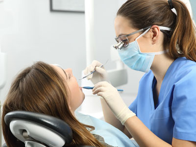 A dental hygienist assisting a patient during a teeth cleaning appointment.